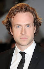 Rafe Spall como 