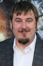 Travis Beacham som Director