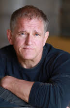 David Lansbury como U.S. Court Prosecutor